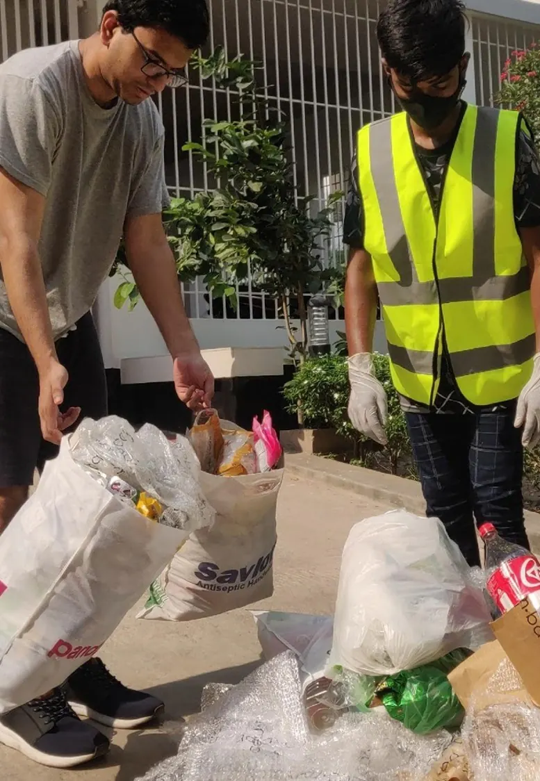 A household member and Garbageman worker sorting separated recyclable materials